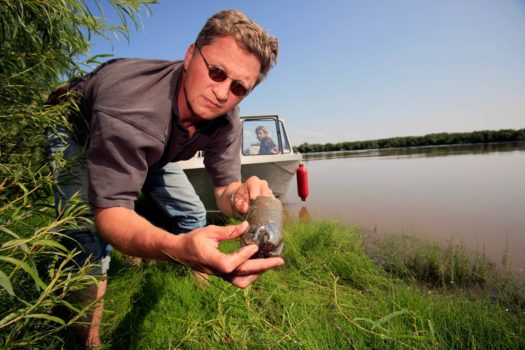 Greenpeace Germany campaigner Christoph von Lieven collects water and soil samples from the tailings pond next to the Syncrude upgrader plant north of Fort McMurray, northern Alberta, 2009