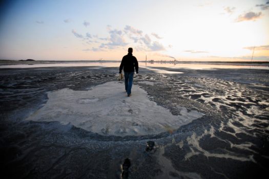 Greenpeace Germany campaigner Christoph von Lieven collects water and soil samples from the tailings pond next to the Syncrude upgrader plant north of Fort McMurray, Alberta, 2009