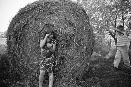 Thomas and Alisha, children of Whole Village members and seasonal volunteers (ecovillage and biodynamic farm), play around a hay bale near one of the community's cultivated fields. From the series 'Salt and Earth' 2008

© Jonathan Taggart