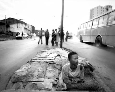 Bruke is a 15 year old boy who has lived on the streets of the Merkato district of the Ethiopian capital, Addis Ababa, for 5 years. He lives in a small hole - a 3ft deep by 5ft by 4ft concrete culvert covered with debris to camouflage it - in the center of the main street, often sharing it with his friend Oromo. Bruke is one of some 80,000+ homeless children living in the district. Many of the children end up on the street because they have escaped from lives of indentured slavery: brought to the capital with the promise of education and employment, in reality they become part of the human trafficking circuit that abounds throughout Ethiopia.