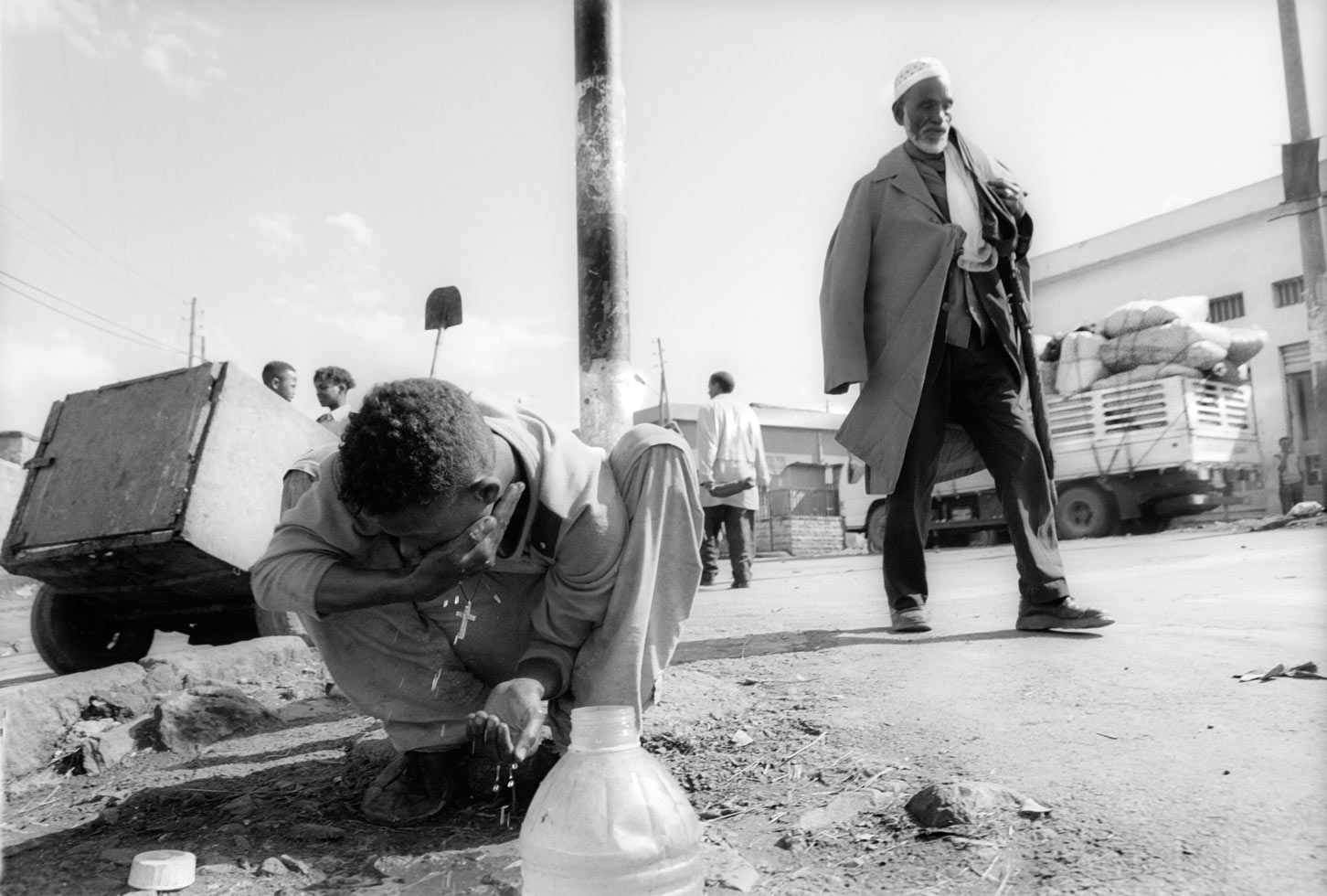 Bruke has nowhere to wash except on the street near the hole where he lives.