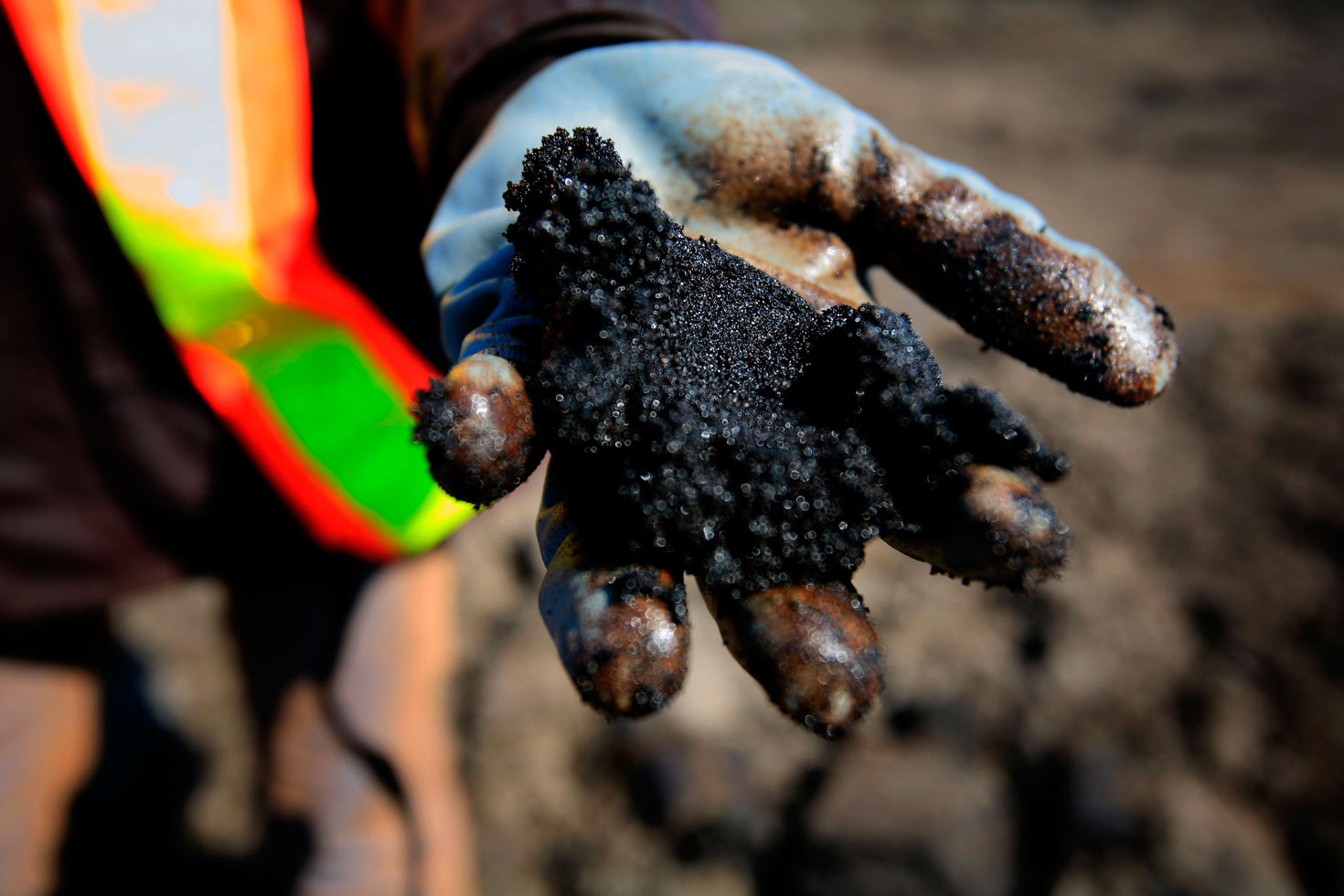 WWF UK staff member Alexandra Hartridge displays oil-rich bitumen sands at the Shell Albian Sands mining operation.