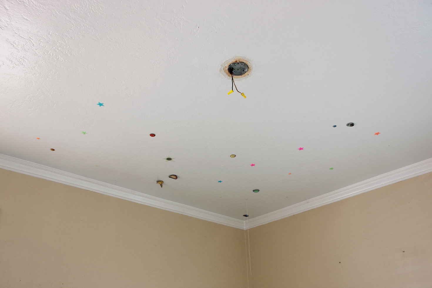 Foreclosure, USA: Galaxy, 2009

Plastic stars, solar system stickers, and a missing light fixture on the ceiling of a foreclosed home.