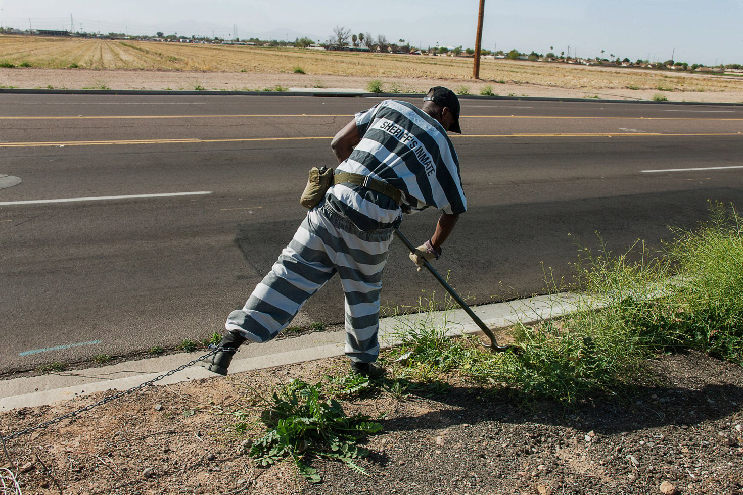 A chain gang inmate performs weeding duties in the Phoenix area.