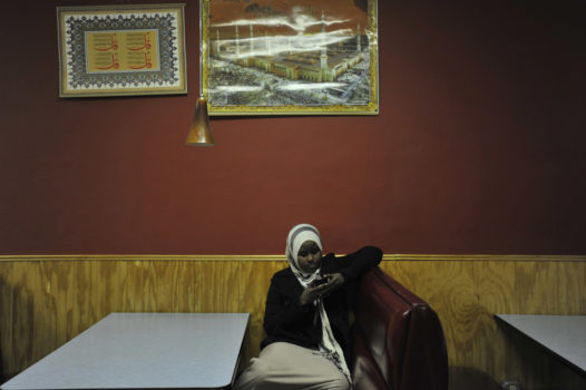 Hamdi texts her friends while waiting in the Quruxlow restaurant in Minneapolis.