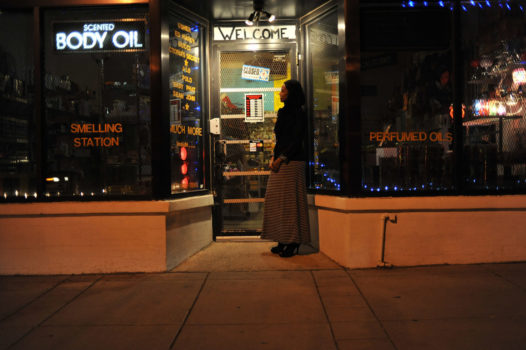 Farah Hassan looks in a store window at perfumes and handbags after the store in Minneapolis has closed.