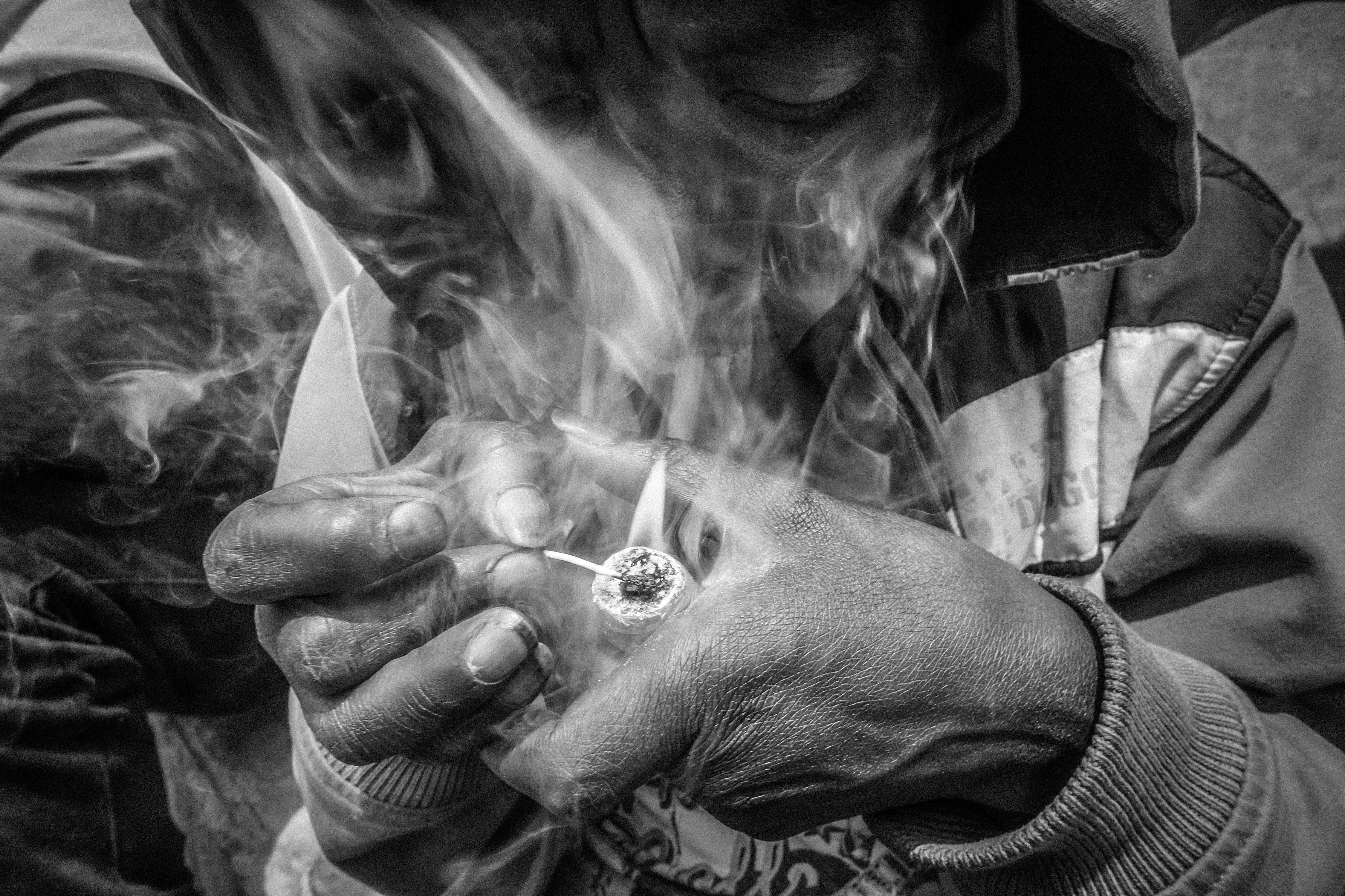 A woman on the street smokes bazuko or 'little devil', a cheap form of crack. 

Colombia.