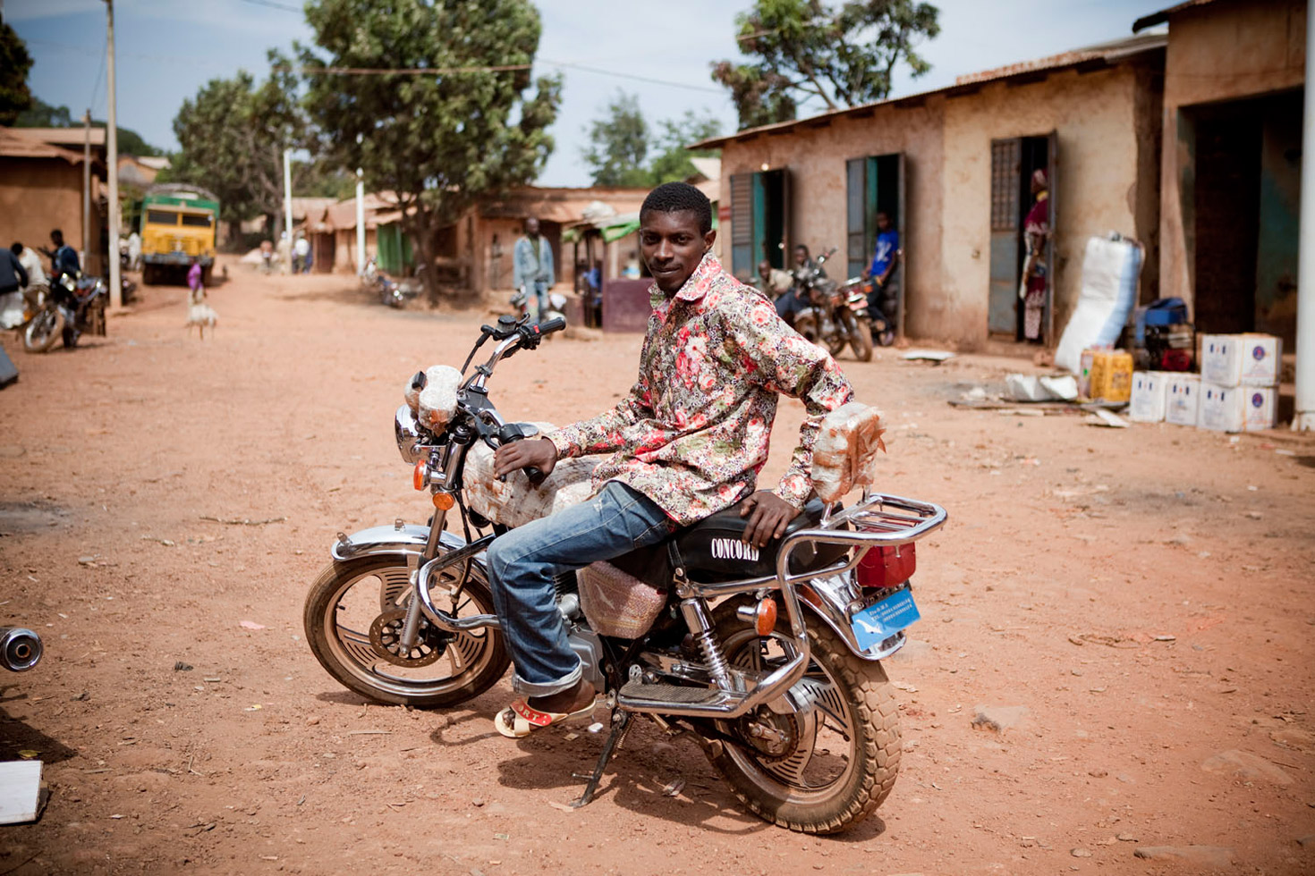 Portrait of 'Ibou,' a motorcycle taxi driver in Maliville in the Fouta Djallon highlands of Guinea. He makes the arduous 60 km, 10 hour ride down the steep, rock-strewn paths of Fouta to Senegal, up to three times a week. The Guinean roads are reported as being some of the worst in the world.