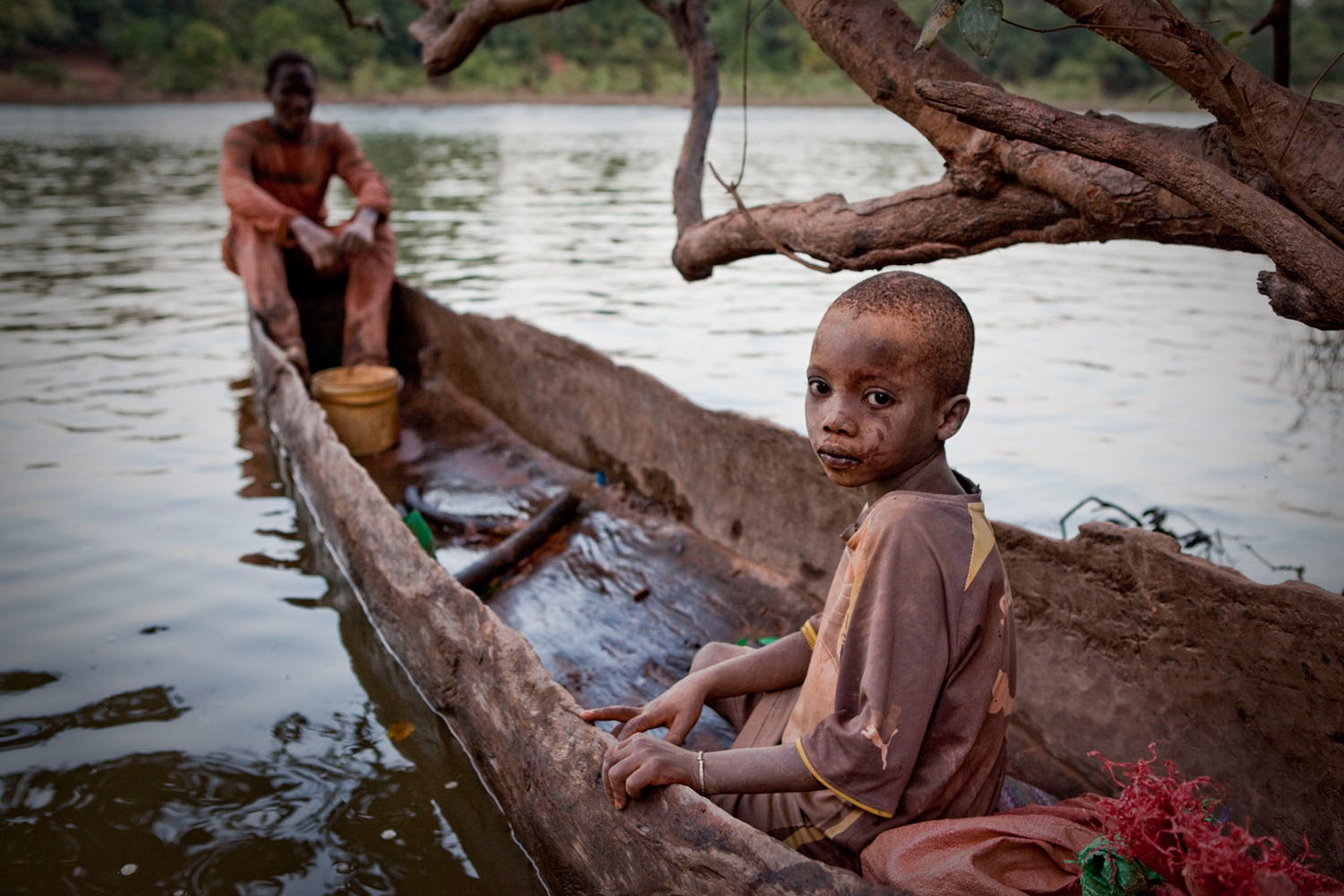 A young mine worker waits to be ferried across the River Gambia after working with his father at one of eastern Senegal's artisanal gold mines.