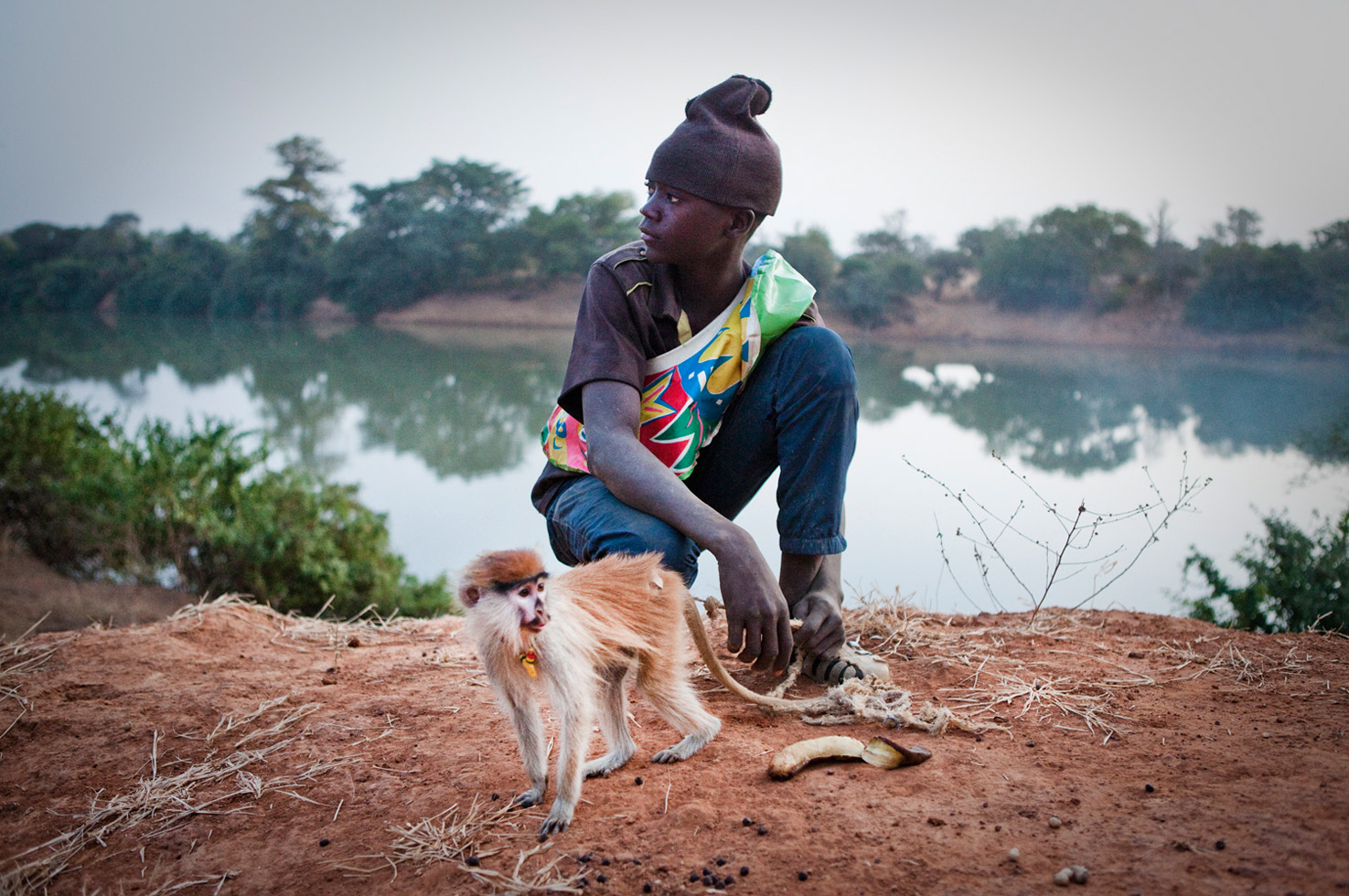 Musa Djallow with his pet red monkey. The mother had been hunted and killed for bush meat and Musa rescued the orphaned baby.