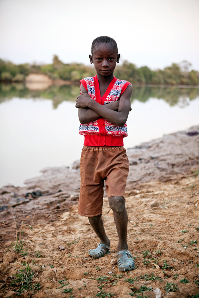 A young boy poses next to River Gambia at Diagabu Tenda.