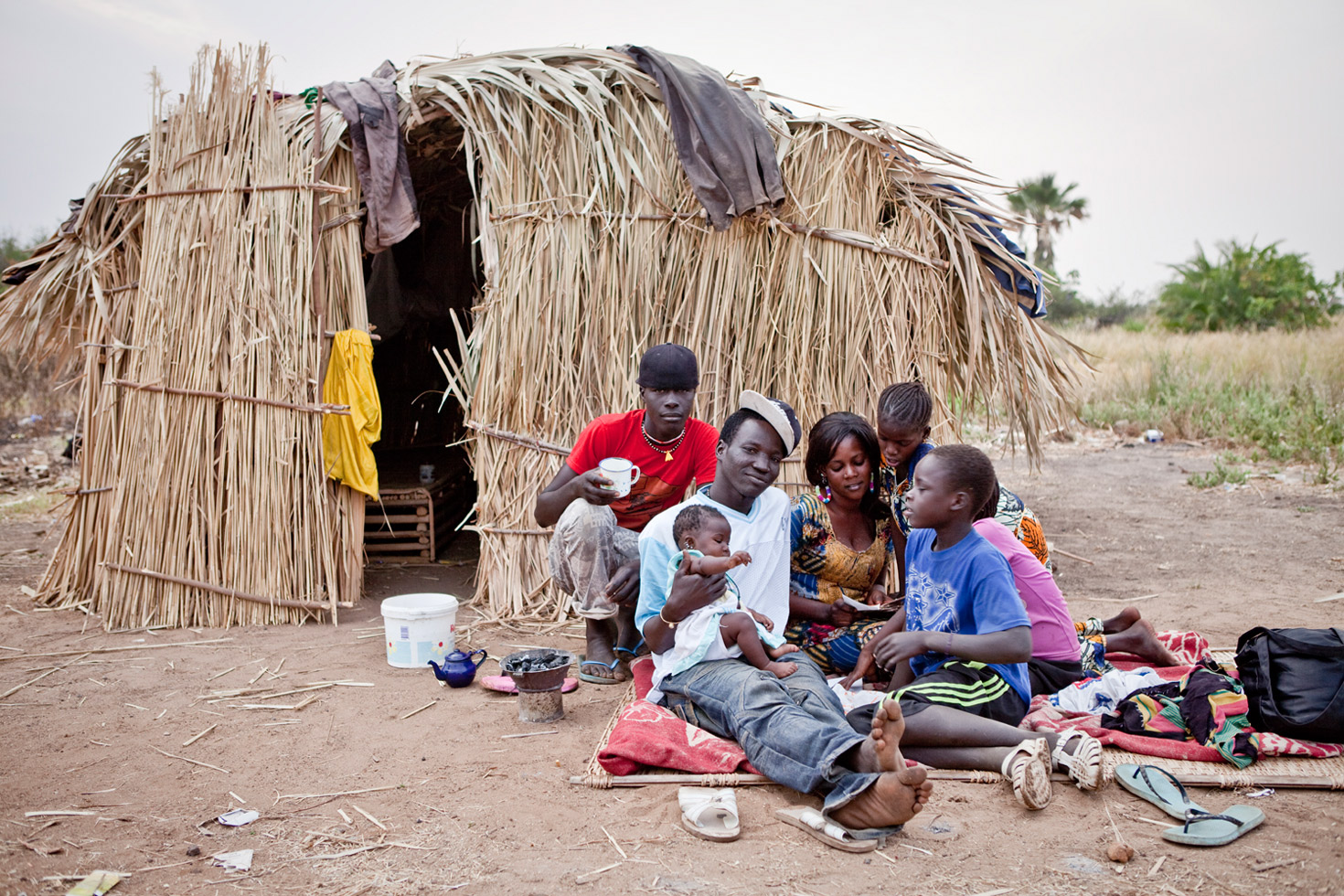 A migrant fisherman from Senegal with his family outside their seasonal fishing hut at Carrol's Wharf, The Gambia.
