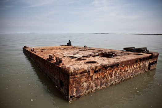 A watchman relaxes on a floating jetty near the small Gambian village of Bonto. Bonto became infamous in 2009 when a two-tonne cocaine stash was discovered in a riverside warehouse a few hundred meters from the jetty. The street value far exceeded Gambia's $782 million annual GDP that year.