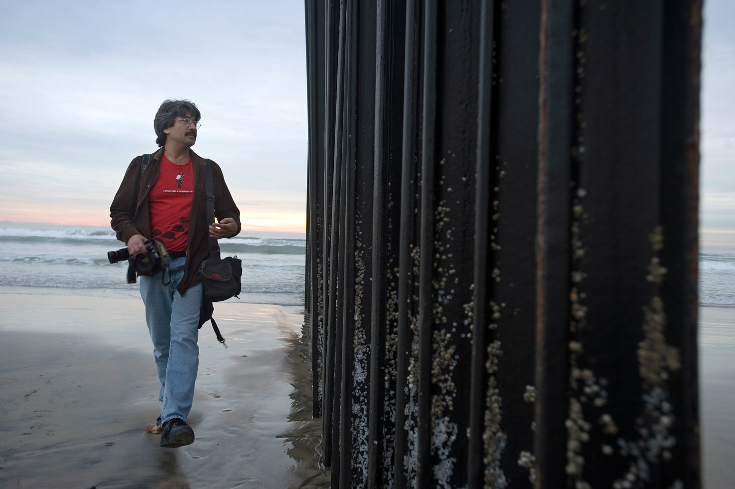 Photographer David Maung at the border fence in Playa Tijuana.