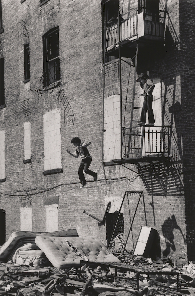 Martha Cooper 
"Lower East Side [Boy Jumping from Fire Escape]"1978 (printed later)

Gelatin silver print. Museum of the City of New York. Museum purchase.