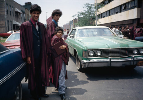 Grads pose near cars, Bushwick, Brooklyn, NY, 1982