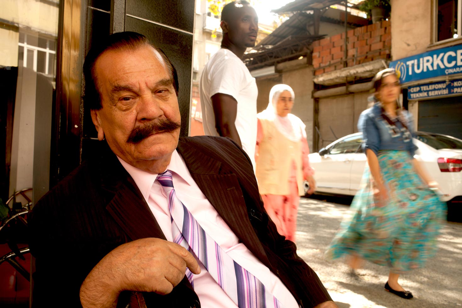 Rhami Pala, an old Turkish actor, enjoying Kurdish, Gypsies, Armenians and Africans passing at the crossroads.