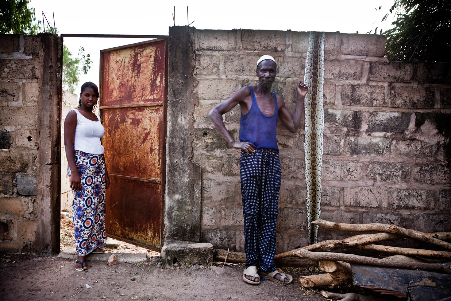 A fisherman poses with the skin taken from a python that was caught in his net near the Gambian town of Bansang.