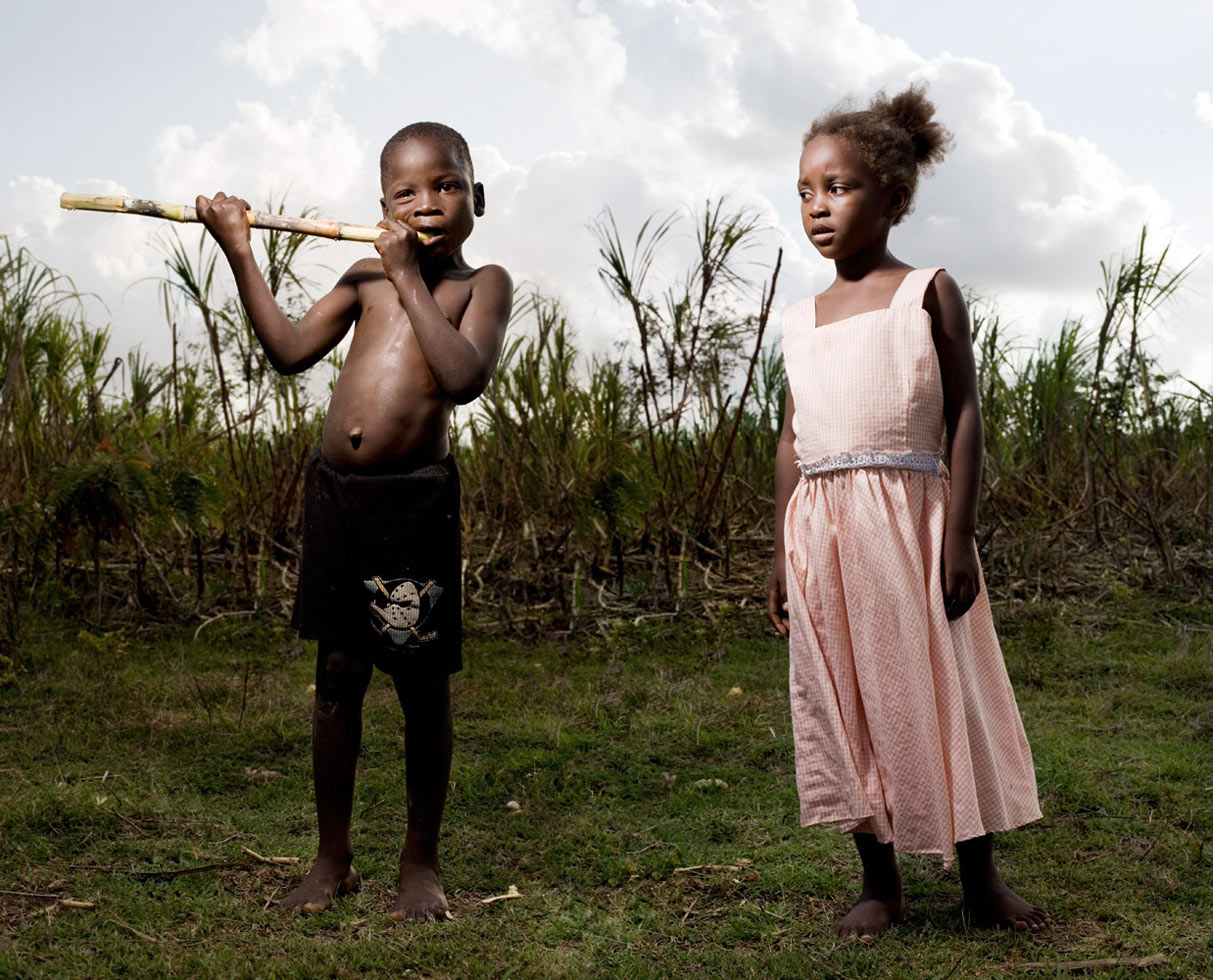 Lost in the vast sugarcane fields of the Dominican Republic, there are hundreds of small villages called Bateys. These underdeveloped towns were established in the beginning of the 20th century to house migrant Haitian workers during the sugarcane season. Images and text by Reed Young, reporting from Batey Las Pajas.

Berto "Papa" and his sister, Marciel "Cyclone," grew up with a back yard full of sugar cane. Marciel is appropriately known throughout the Batey as Cyclone because her mother gave birth to her soaking wet on the day of Hurricane George. George swept through Las Pajas on September 22, 1998, flattening all homes built out of wood and scrap metal and leaving only some of the barracks standing.