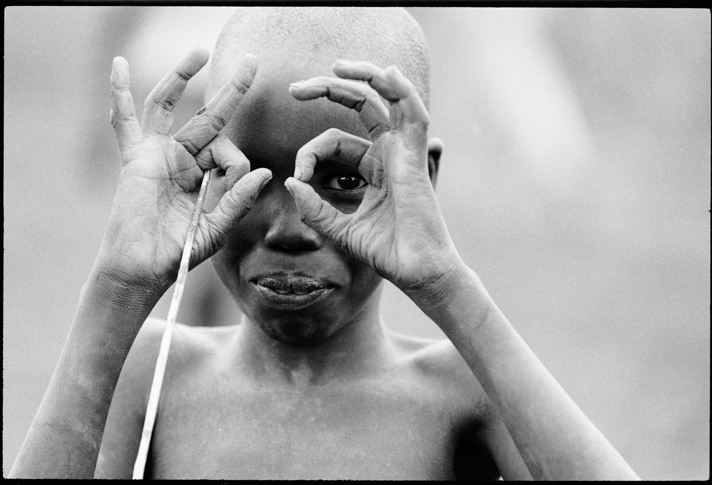 Words and images from Betty Press.

"When a child behaves like an adult he sees what an adult sees." African proverb

I was on assignment to document famine in war-torn southern Sudan. It was a very difficult time for the people but the children always made the best of the situation. This young boy cleverly got my attention by imitating me, the photographer.

Southern Sudan, 1993