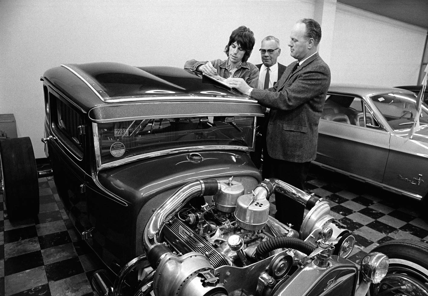 Jeff Beck, S&C Ford, San Francisco, 1968

(Beck) asked me if I knew where he could buy an American hot rod so I took him to the showroom of a car dealer who had one which was for sale. Jeff was immediately fascinated with the car and decided to buy it on the spot. I photographed him writing a check to the dealership. I later heard the car never made it to the UK - something about shipping or permit issues.
