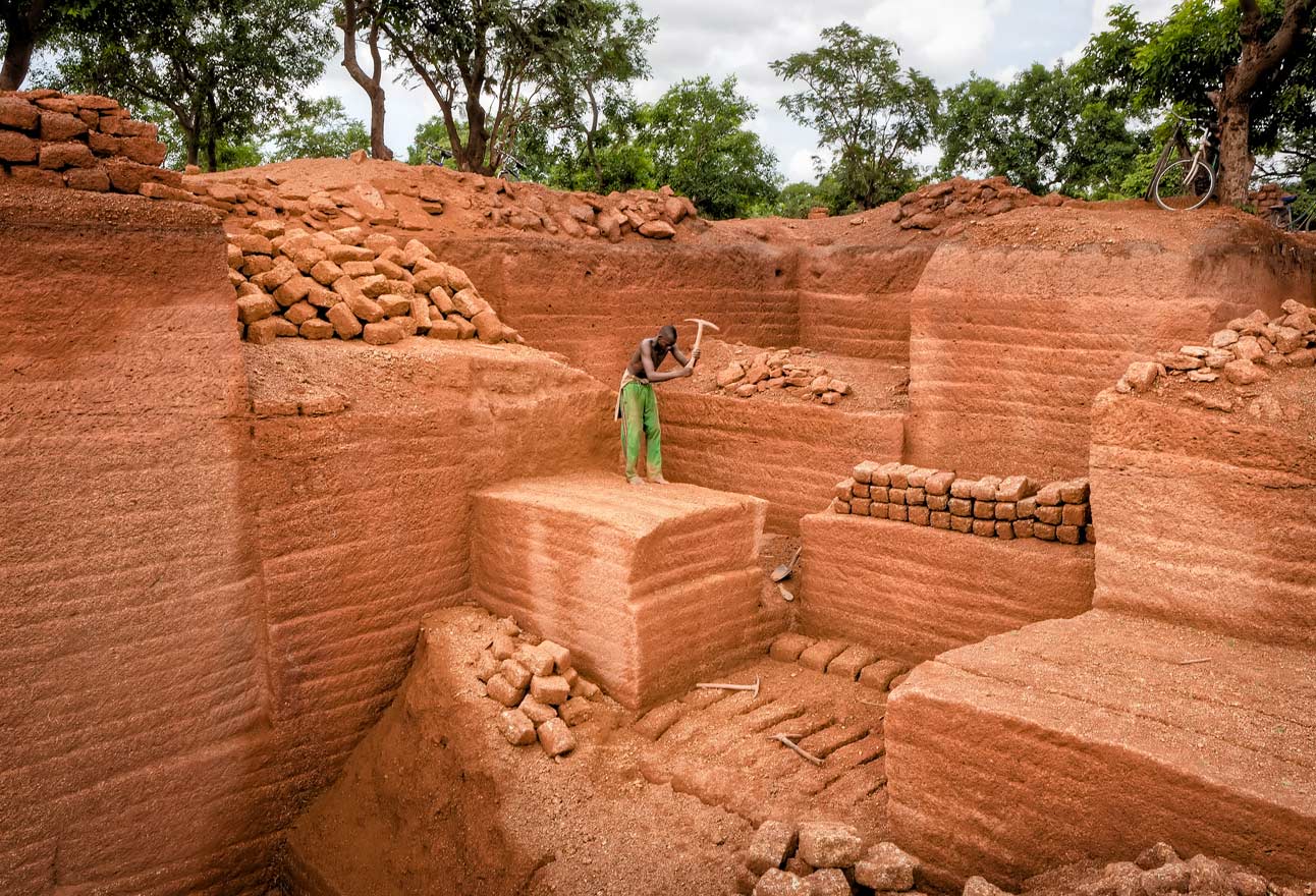 The dried bricks are transported in wooden carts drawn by mules and used to construct simple houses.
