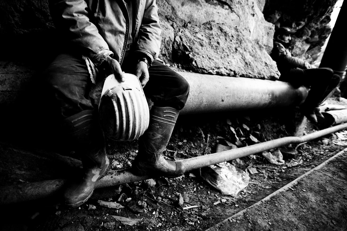 A miner takes a break in front of the gallery entrance between his shifts. Ten miners are working to pump out water from the 16th level of the mine, 1600m underground. If they stop working the mine will fill up with water.