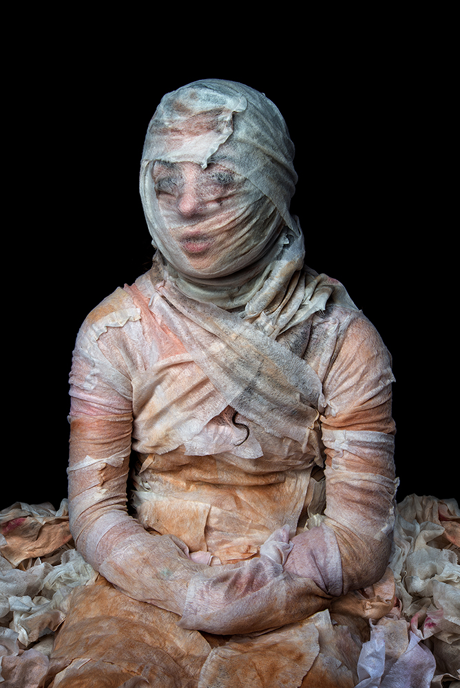 "The application of makeup in the morning and the removal at night is a daily ritual for many women. By collecting used makeup remover wipes from one hundred women, placing them back over the figure and photographing them, these images embody this repetitive beauty ritual."