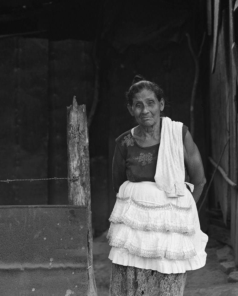 Julia, 70. Julia was busy in her kitchen making her family's dinner when we asked her to pose. She agreed, and wanted to take off her apron for the photo, but I convinced her to leave it on. I thought it was pretty fancy for such an impoverished setting.